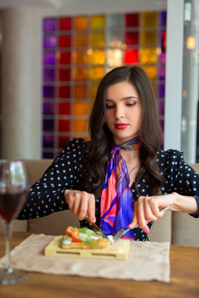 beautiful young woman eats in a restaurant - Foto, Imagen