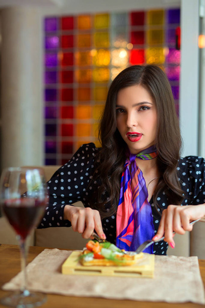 beautiful young woman eats in a restaurant - Foto, Imagen