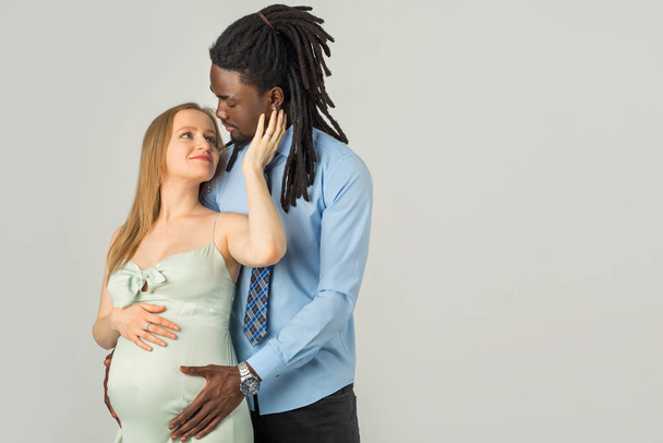 beautiful young family expecting a baby on a white background - Zdjęcie, obraz