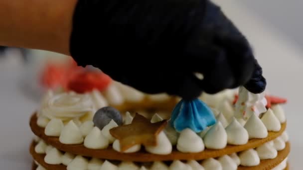 Kobieta ozdabia tort w kuchni. cukiernik w pracy - Materiał filmowy, wideo