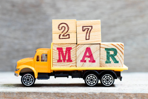 Truck hold letter block in word 27mar on wood background (Concept for date 27 month March) - Fotografie, Obrázek