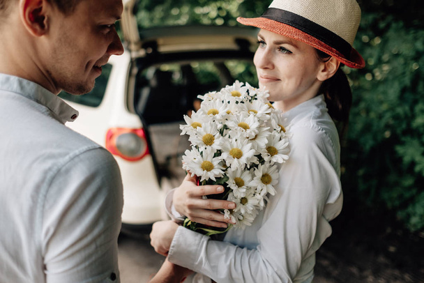 Giovane coppia felice vestita come in bianco T-shirt Divertimento vicino alla macchina, Weekend fuori città, Vacanze e Road Trip Concept
 - Foto, immagini