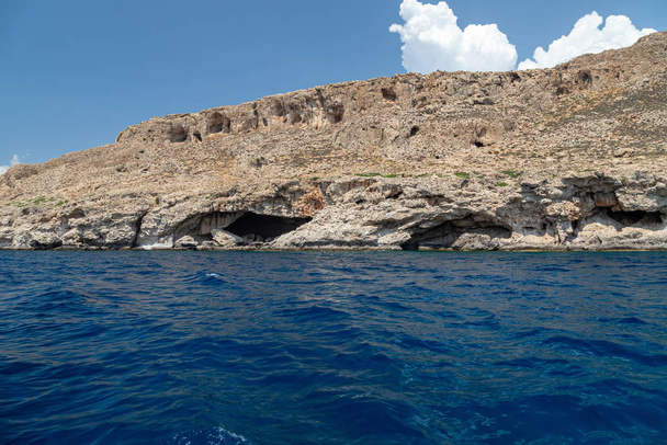Vista de um barco a motor no mar Mediterrâneo no cacau rochoso
 - Foto, Imagem