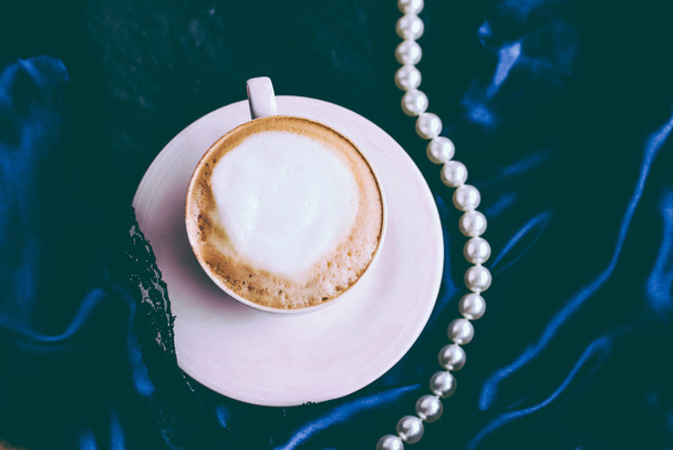 Copa de capuchino para el desayuno con joyas de satén y perlas
  - Foto, imagen