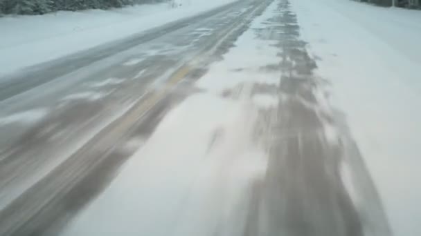 IJzige weg glinstert snel onder de wielen van een snelrijdende auto in ijzig Finland Mesmerizing uitzicht op een twinkelende snelweg bedekt met sneeuw vliegen rond onder de wielen van een snelrijdende auto in koud Finland in de winter. Het ziet er mooi en dromerig uit.. - Video