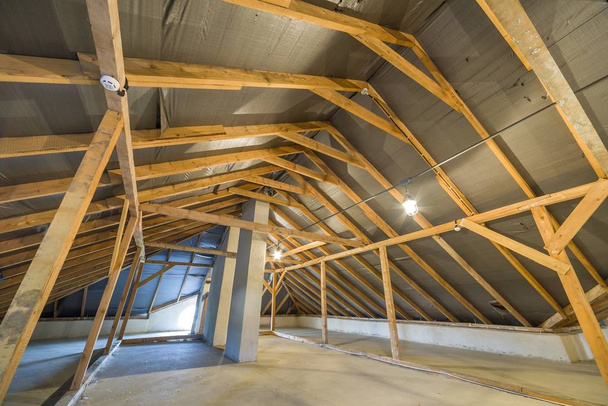 Dachgeschoss eines Gebäudes mit Holzbalken einer Dachkonstruktion. - Foto, Bild