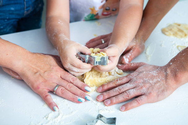 Perhe tekee kotitekoisia kakkuja. Äidit ja lapset pitelevät keksileikkureita. Perhe ruoanlaitto tasainen lay. Ihana koti. Onnen käsite
.  - Valokuva, kuva
