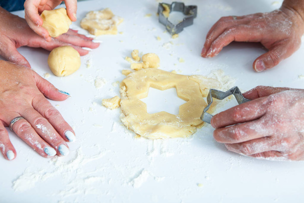 Family cooking homemade cakes. Moms and children hands holding cookie cutters. Family Cooking flat lay. Sweet home. Happiness concept.  - Photo, image