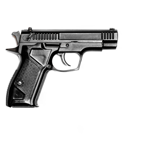 Eine schwarze Pistole liegt vor weißem Hintergrund. Vereinzelt. Blick von oben. Nahaufnahme - Foto, Bild