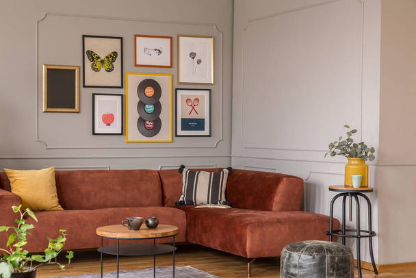 Elegant coffee table in front trendy sofa in modern living room interior with grey wall - Фото, зображення