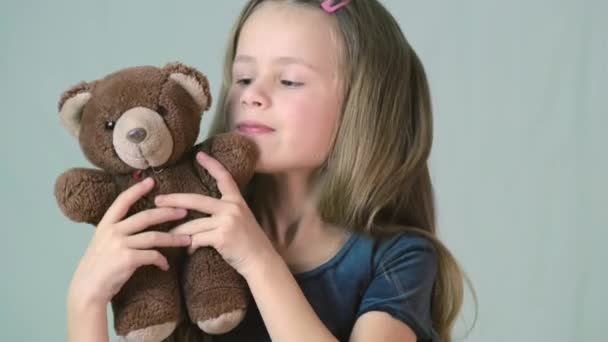 Pretty child girl playing with her teddy bear toy. - Materiał filmowy, wideo