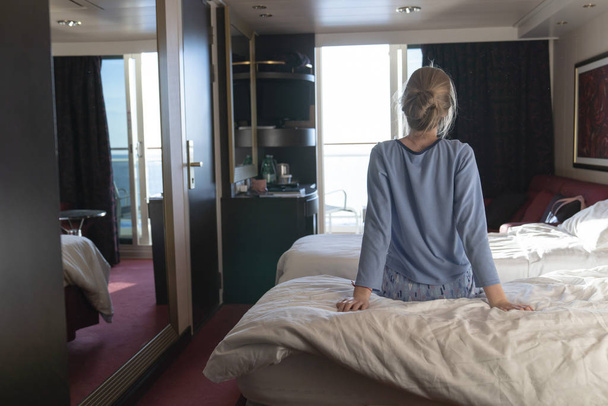 Female teenager enjoying watching sunrise from cabin luxury cruise ship. The concept of meeting the dawn on a cruise ship. Travel, sea, cruise - Foto, immagini
