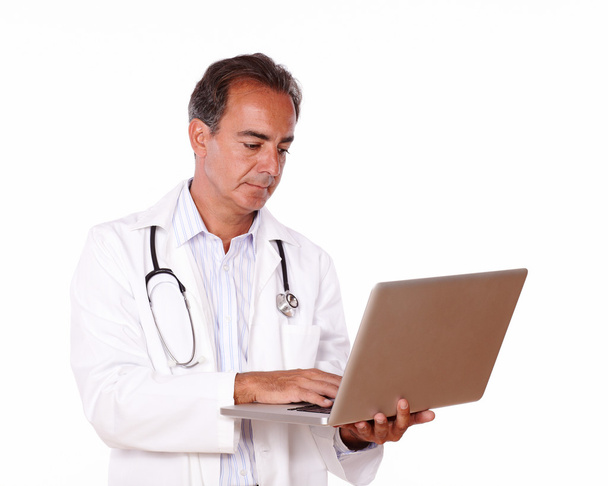 Mature doctor working on his laptop - 写真・画像