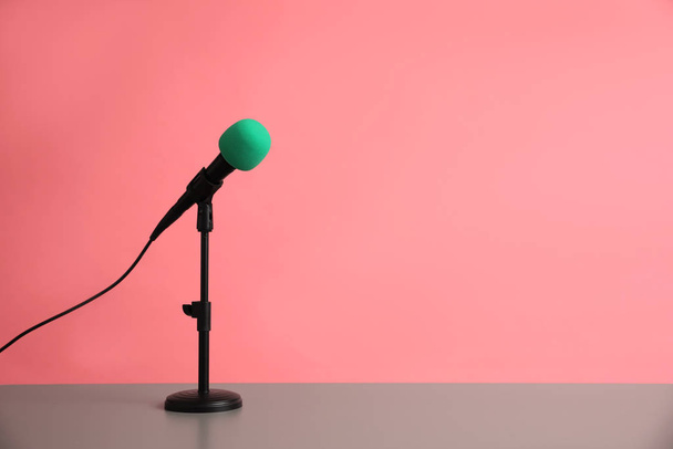 Microphone on table against pink background, space for text. Journalist's work - Fotó, kép