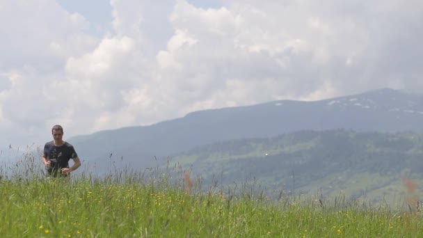 Jongeman toerist steekt zijn hand op in winnaarsspijsvertering tijdens een wandeling in de zomer bergen. - Video