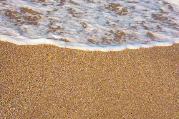 Meereswellen spritzen Schaum auf den sonnigen Strand - Foto, Bild