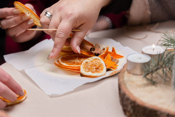 Women's hand making decorations from dried oranges, stars from t - Valokuva, kuva