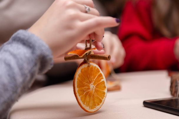 Women's hand making decorations from dried oranges, stars from t - Photo, Image