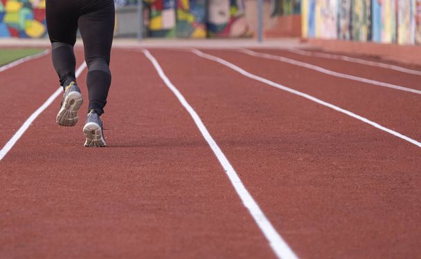 un par de piernas atléticas yendo a correr en una pista de atletismo
 - Foto, Imagen