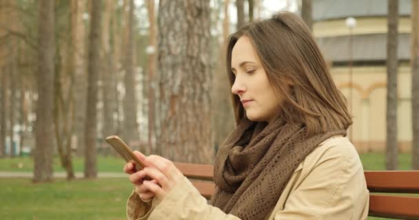 Jonge vrouw met mobiele telefoon en vegen en scrollen sociale netwerken glimlachend en lachend genieten van haar sociale leven. Internet-levensconcept - Video