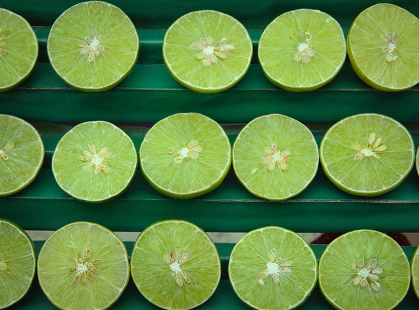 Свежие нарезанные зеленые лимоны или лайм. Спелый сочный лимонад
.  - Фото, изображение