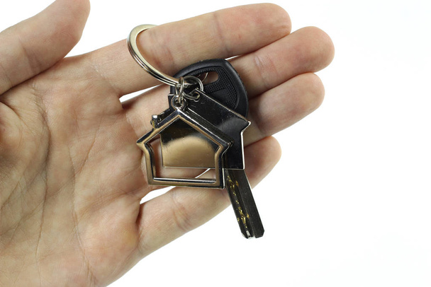 Un hombre tiene las llaves de una casa nueva en su mano. Aislado sobre fondo blanco
 - Foto, Imagen