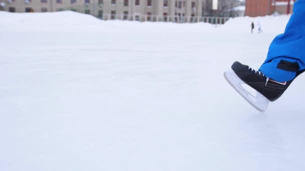 A korcsolya pengéje átvágja a jeget. A jégkorong játékos fékez a jégen. A jégkorcsolya közelsége. - Felvétel, videó