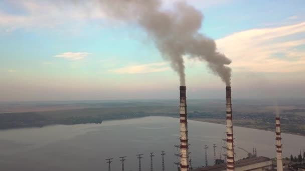 Kömür santralinden gelen gri dumanlı yüksek baca borularının havadan görüntüsü. Fosil yakıtla elektrik üretimi. - Video, Çekim