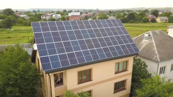 Bovenaanzicht vanuit de lucht van nieuw modern woonhuis huisje met blauw glanzende zonne-energie fotovoltaïsche panelen systeem op dak. - Video
