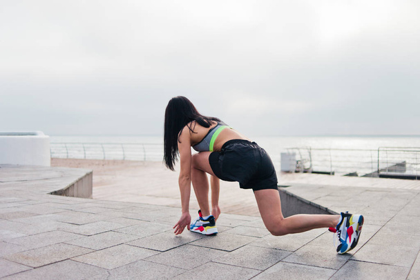 Giovane donna sportiva in abbigliamento sportivo sempre pronto correre in spiaggia - Foto, immagini