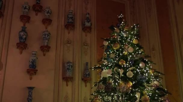 Gran árbol de Navidad con luces brillantes, adornos y regalos en una casa bellamente decorada. Dolly disparó. - Metraje, vídeo