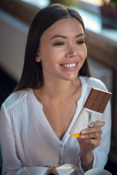 Cara de una joven feliz comiendo chocolate
 - Foto, imagen