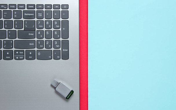 Laptop with USB flash drive on a colored background. Top view - Foto, Bild