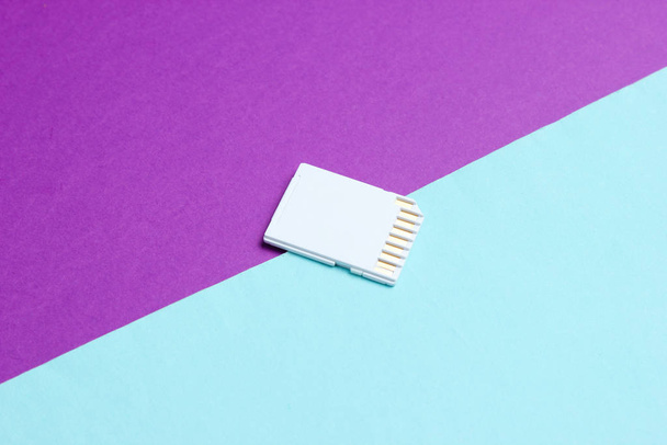 Mini SD memory card on blue purple paper background close up - Valokuva, kuva