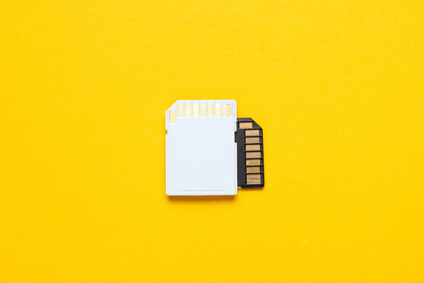 Two Mini SD memory cards on yellow background. Top view - Φωτογραφία, εικόνα