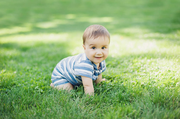 7 month child crawls on grass in yard, - Photo, Image