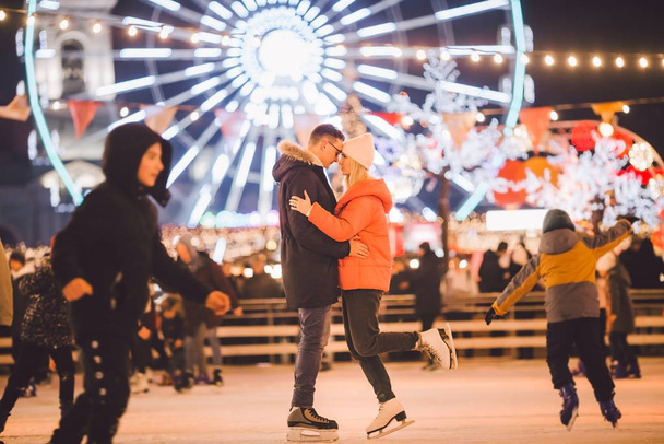 Gyönyörű pár érezzék jól magukat a jégarénában. aktív dátum jégkorcsolyázás az esti főtéren télen karácsony este. Valentin-nap a városi jégpályán. Szilveszter ünnep város Kijev - Fotó, kép