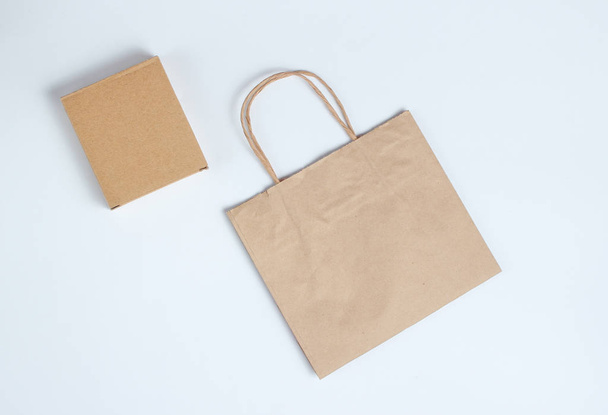Cardboard box and paper bag on a gray background. Top view. - Foto, Bild
