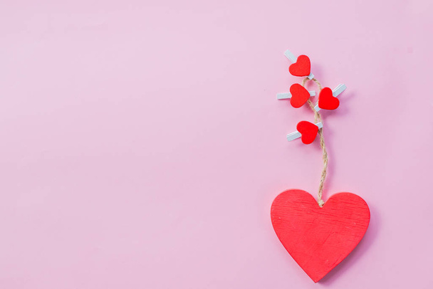 esküvői vagy Valentin napi üdvözlőlap. Piros szív rózsaszín háttérrel. Kreatív kártya Valentin nap előtt. Szerelem, szenvedély, kapcsolat koncepció. - Fotó, kép