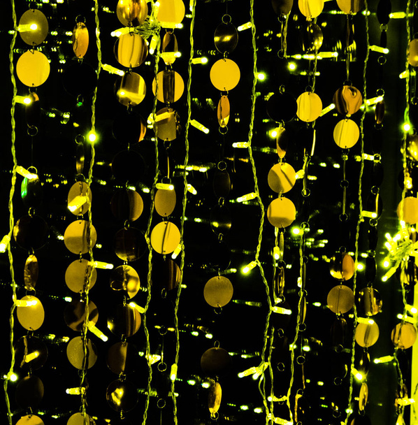 Golden balls in garlands decorate the interior. Festive attire in celebration of the New Year and Christmas. Gold and black abstract background - Photo, Image