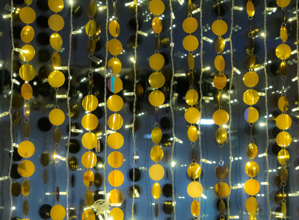 Интерьер украшают золотые шары в гирляндах. Праздничный наряд в честь Нового года и Рождества. Золотой и черный абстрактный фон
 - Фото, изображение