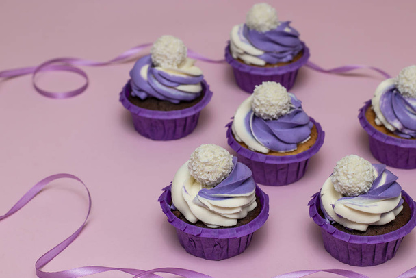 Cupcakes caseros con crema lila sobre fondo rosa, concepto para San Valentín o cumpleaños, orientación horizontal
 - Foto, Imagen
