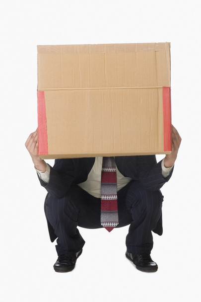 Businessman holding a cardboard box - Foto, afbeelding