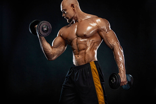 Strong and fit man bodybuilder. Sporty muscular guy with dumbbells. Sport and fitness motivation. Individual sports recreation. - Foto, imagen