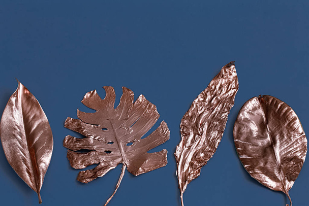 The background is painted with leaves of gold color on a blue ba - Foto, imagen