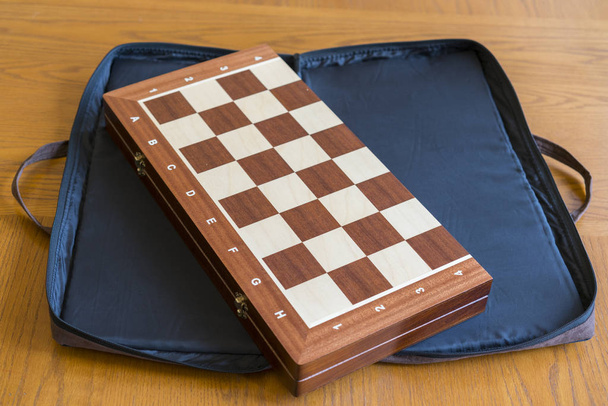 Uzavřená šachovnice zblízka. Uzavřená šachovnice pro šachy na dřevěném stole. - Fotografie, Obrázek