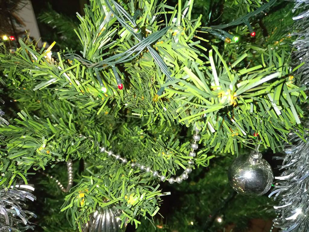 Adornos del árbol de Navidad con globos, instalación y oropel
 - Foto, Imagen