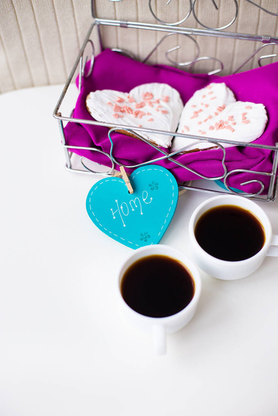 Kekse im Herzen und zwei Tassen Kaffee auf dem Tisch, der nach Hause sagt - Foto, Bild