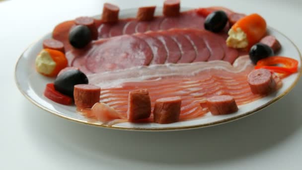 Fette di carne e salsiccia sul piatto accanto alle olive nere, paprica con formaggio e salsicce da caccia. Piatto di carne stagionato
 - Filmati, video
