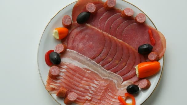 Мясо и колбасные ломтики на тарелке рядом с черными оливками, паприка с сыром и охотничьи сосиски. Мясная тарелка
 - Кадры, видео